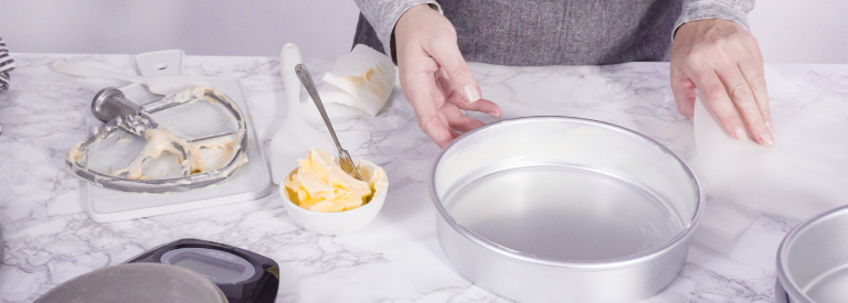 prepping cake pan to bake